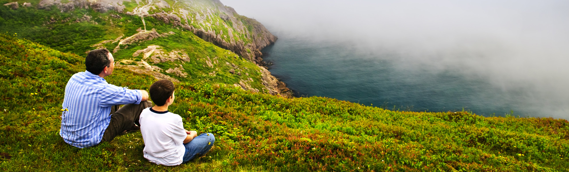 Father and son sat on a cliff